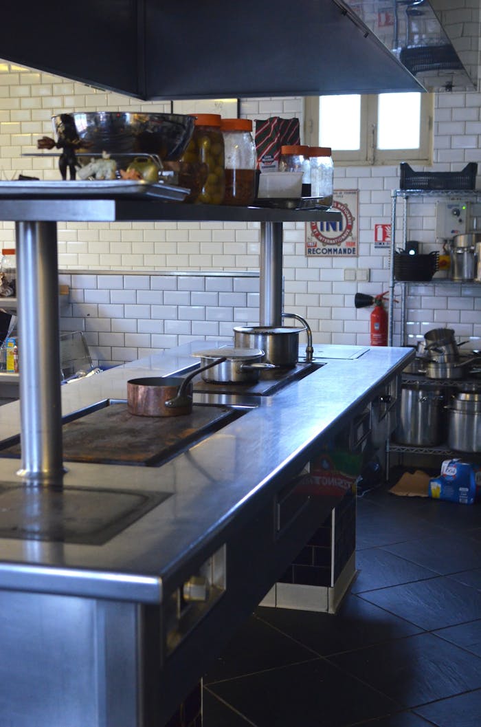 gallery-6 Empty commercial kitchen with stainless steel surfaces and cooking equipment.